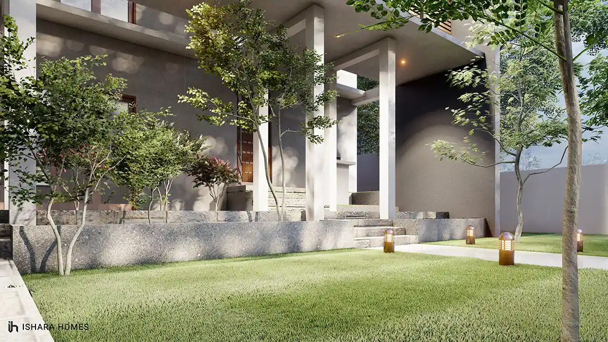 A closer view of the columned porch, its stone-clad base and timber front door softened by ornamental shrubs and low garden lighting along the steps.