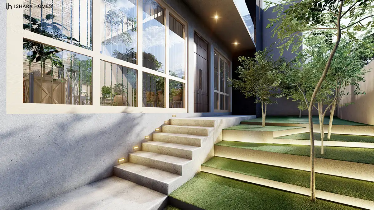 A tiered stone stairway leads from the entrance glazing down into a landscaped courtyard, its illuminated steps and terraced lawn strips creating...
