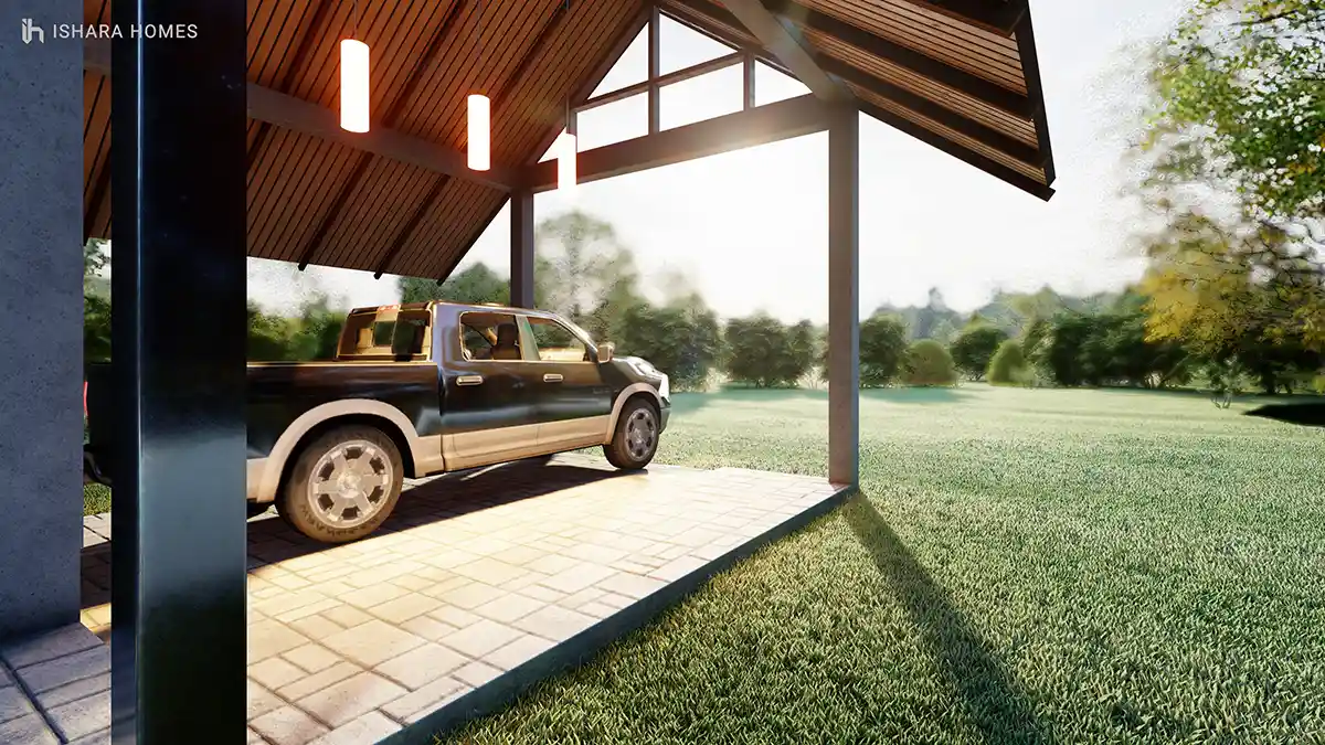 Beneath the angled timber roof of the carport, a pickup truck sits parked on herringbone paving, sunlight streaming across the open lawn beyond...