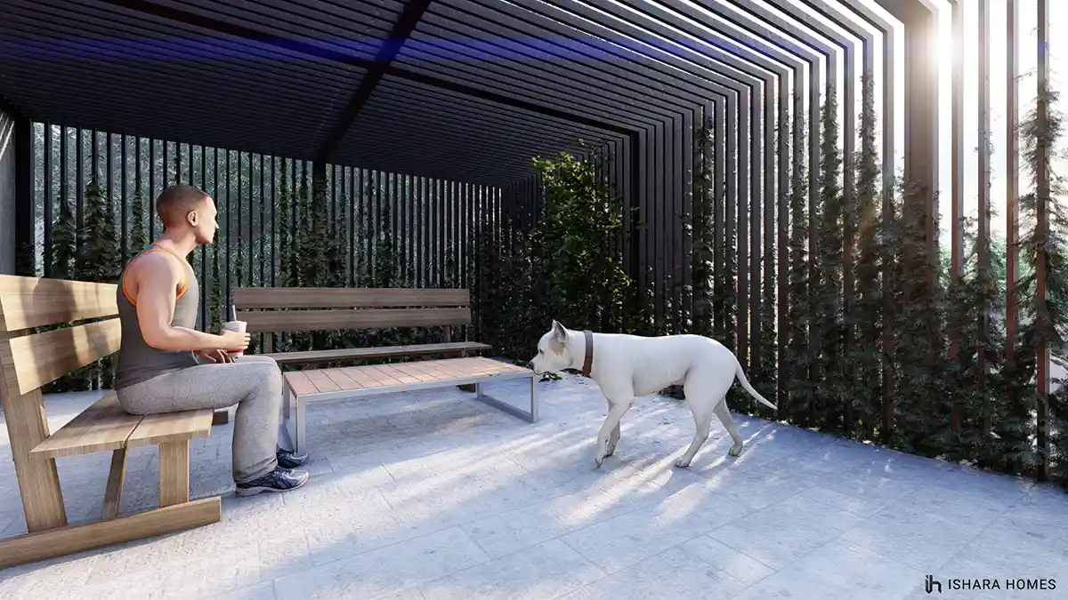 Along a covered side walkway roofed in tight timber slats, a man relaxes on a wooden bench with his dog, the tall wooden screen filtering warm...