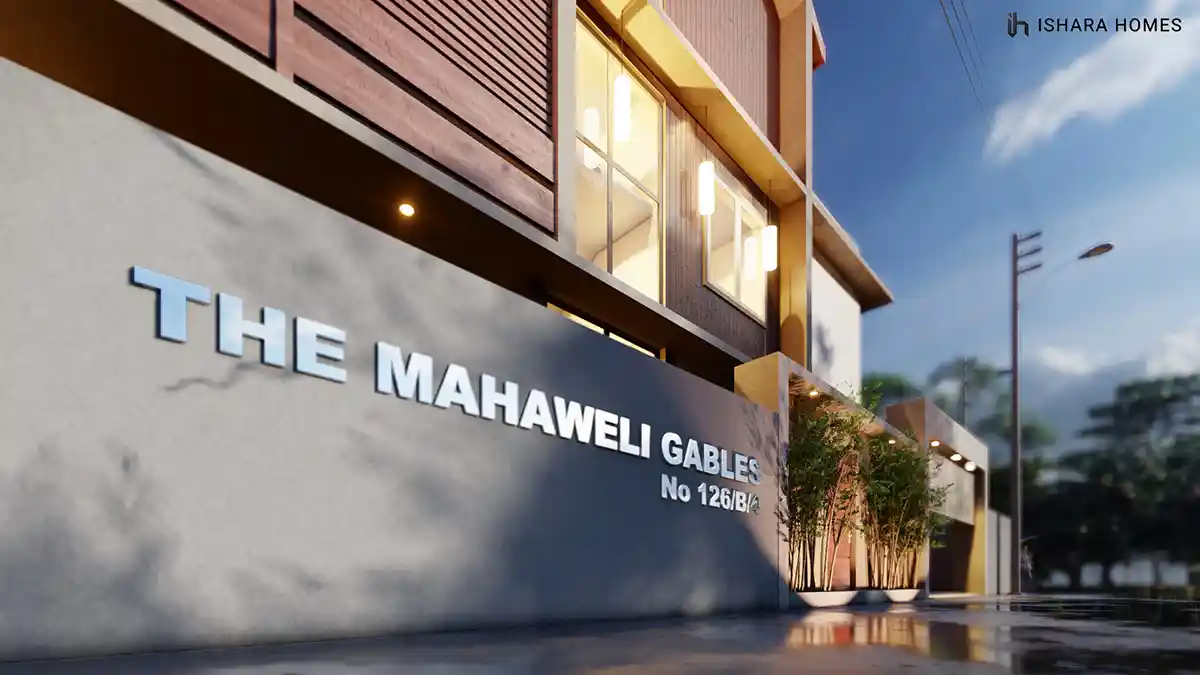 A close view of the entrance wall spells out The Mahaweli Gables in raised lettering, set beneath a timber balcony and glazed upper storey, with...