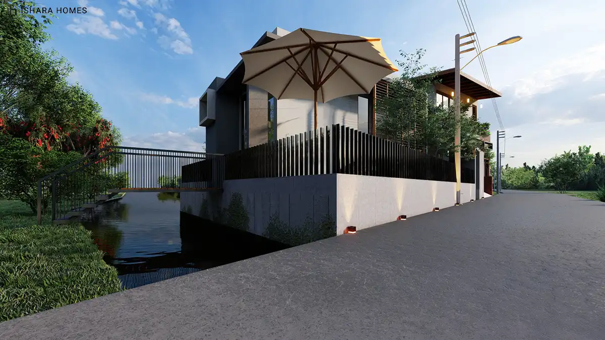 A closer street-level view shows the home's angled roof overhang and glazed corner rising above a low concrete retaining wall, with a garden...